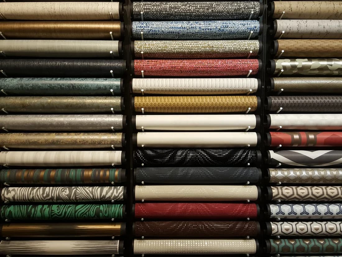 Rolls of wallpaper stacked on shelves in a showroom